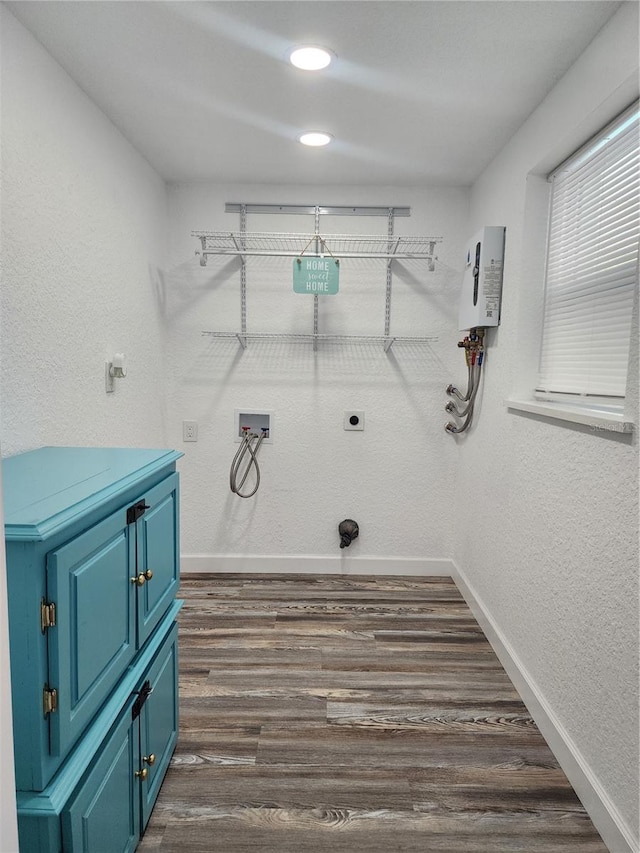 laundry area featuring dark hardwood / wood-style floors, water heater, hookup for a washing machine, hookup for an electric dryer, and cabinets