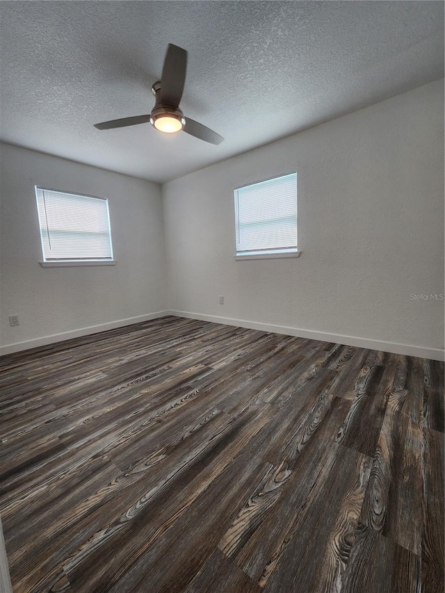 empty room featuring ceiling fan, a textured ceiling, and dark hardwood / wood-style flooring