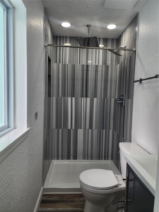 bathroom featuring a textured ceiling, a shower with shower curtain, hardwood / wood-style floors, toilet, and vanity