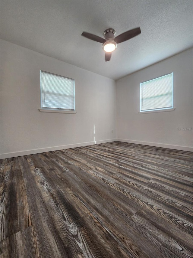 empty room featuring ceiling fan, a textured ceiling, and dark hardwood / wood-style flooring