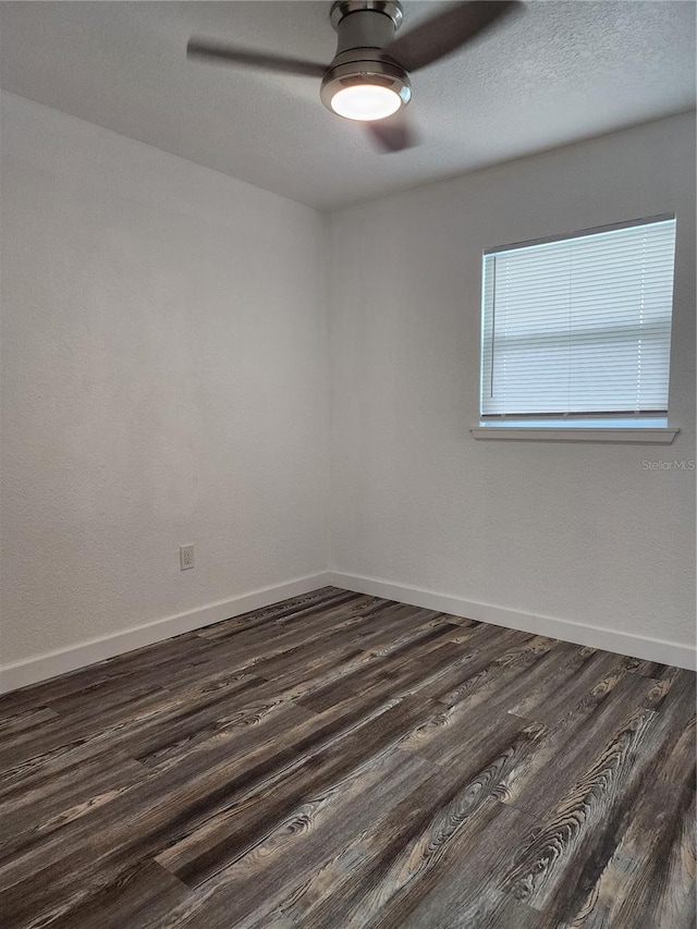 unfurnished room featuring dark wood-type flooring and ceiling fan