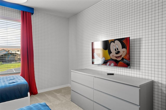 carpeted bedroom featuring tile walls and multiple windows