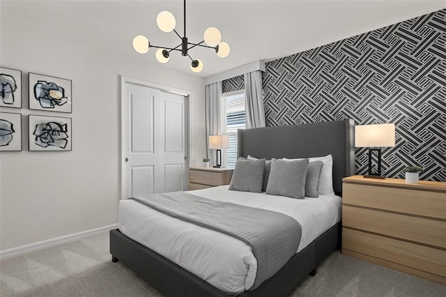 bedroom with a closet, light colored carpet, and an inviting chandelier