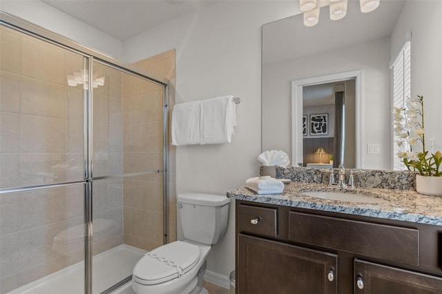 bathroom featuring vanity, toilet, and an enclosed shower