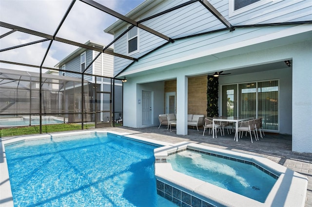 view of swimming pool with an in ground hot tub, a patio area, a lanai, and ceiling fan