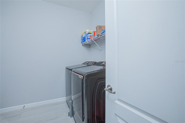 laundry room featuring washer and dryer and light wood-type flooring