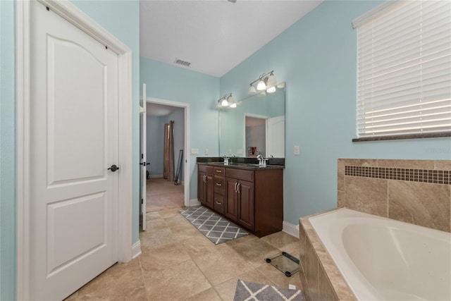 bathroom with vanity, tiled tub, and tile patterned floors