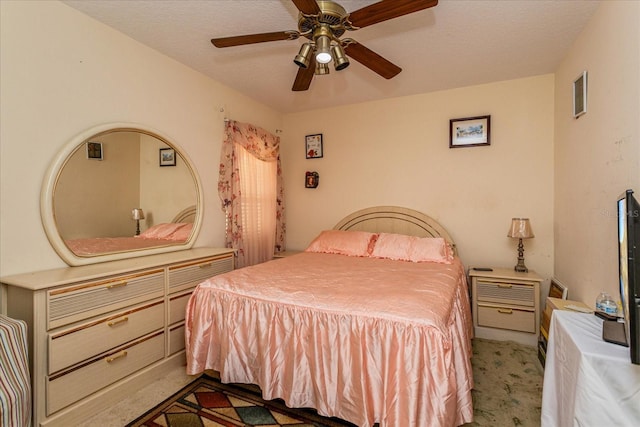 bedroom with ceiling fan, a textured ceiling, and dark colored carpet