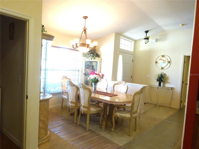 dining area featuring wood-type flooring and a notable chandelier