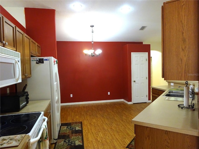 721 Willow Run St, Minneola, FL 34715 - kitchen featuring white appliances, brown cabinets, wood finished floors, baseboards, and decorative light fixtures