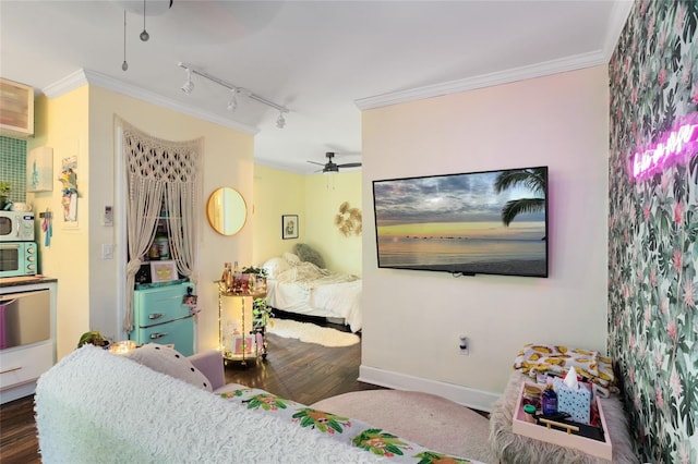 bedroom with rail lighting, ceiling fan, crown molding, and dark hardwood / wood-style flooring