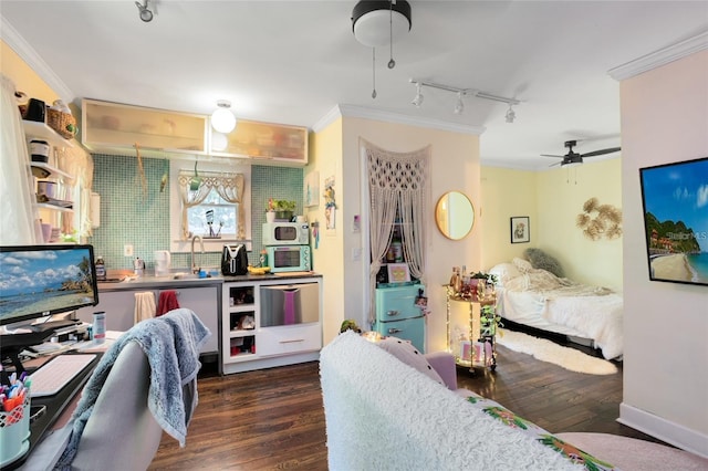 bedroom featuring ornamental molding, rail lighting, dark hardwood / wood-style floors, and ceiling fan