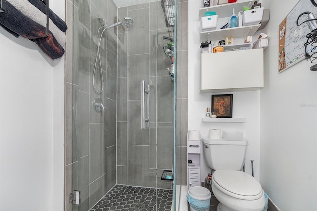 bathroom featuring tile patterned floors, toilet, and an enclosed shower