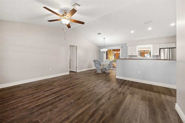 unfurnished living room featuring lofted ceiling, a textured ceiling, dark wood-type flooring, and ceiling fan with notable chandelier