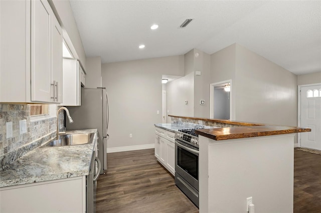 kitchen with sink, stainless steel range oven, dark hardwood / wood-style flooring, white cabinetry, and wooden counters