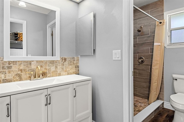 bathroom featuring decorative backsplash, hardwood / wood-style floors, toilet, vanity, and curtained shower