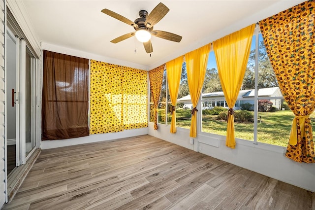 unfurnished sunroom with ceiling fan