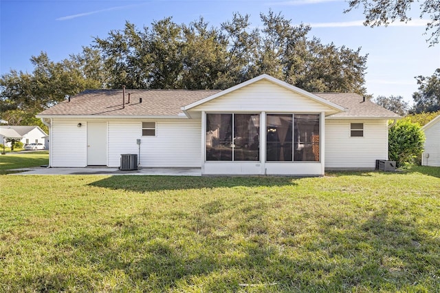 rear view of property with cooling unit, a lawn, and a sunroom