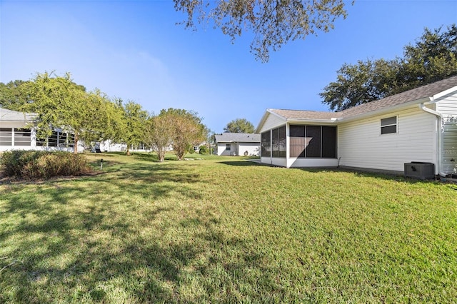 view of yard featuring central AC and a sunroom