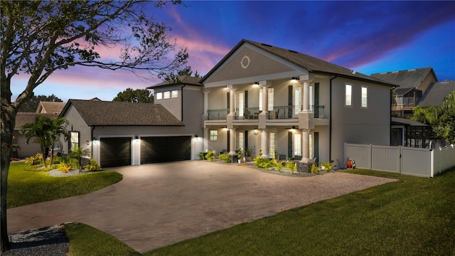 view of front of house with a yard, a balcony, a garage, and ceiling fan