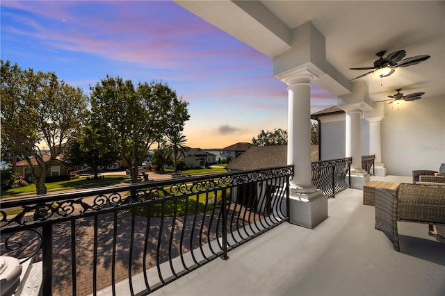 balcony at dusk featuring ceiling fan