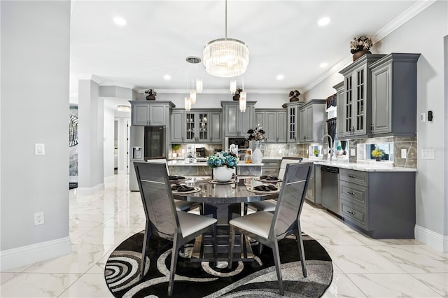 dining area featuring sink, an inviting chandelier, and ornamental molding