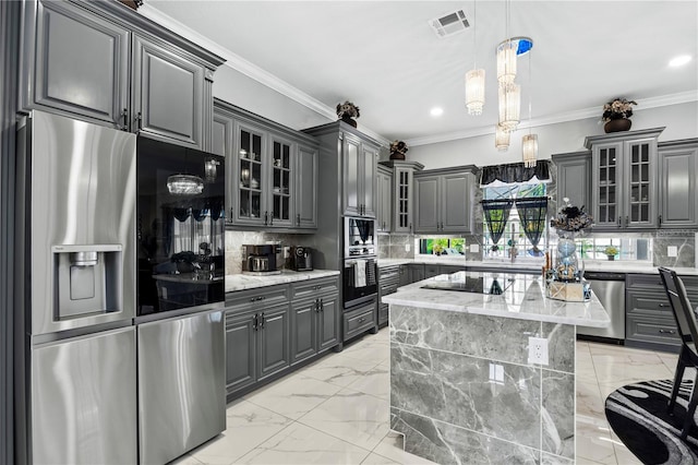 kitchen with appliances with stainless steel finishes, a center island, and gray cabinets