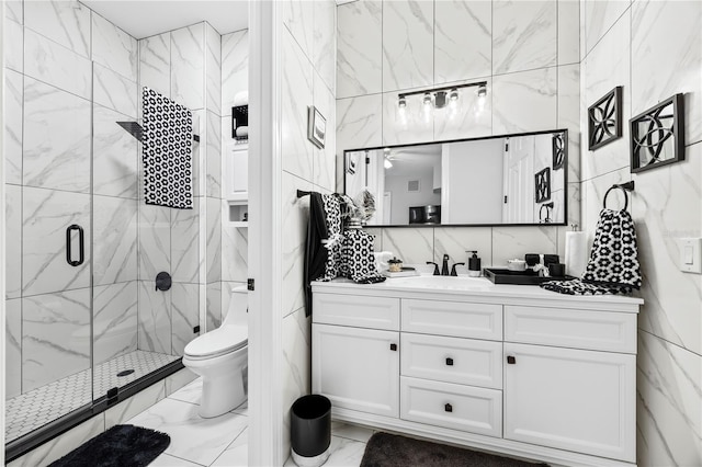 bathroom with vanity, a shower with door, toilet, and tile walls