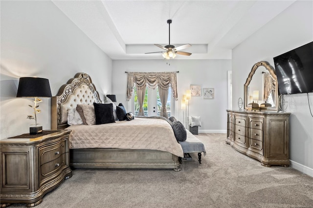 bedroom featuring carpet, ceiling fan, access to outside, and a tray ceiling