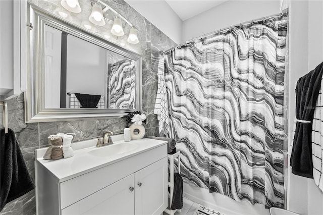 bathroom with shower / bath combo, vanity, tile walls, and backsplash