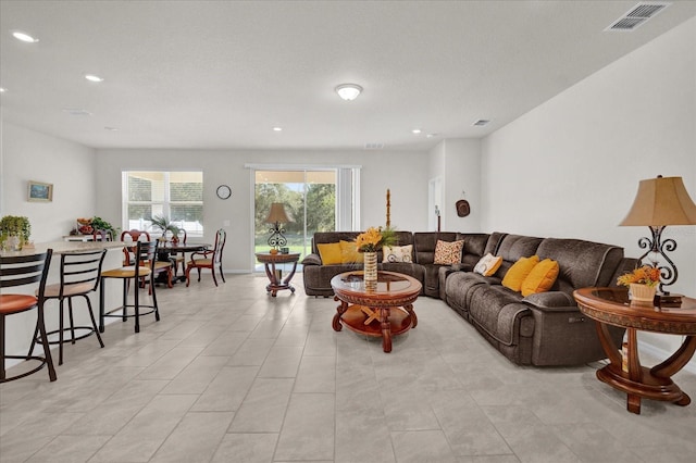 living room featuring a textured ceiling and light tile patterned floors