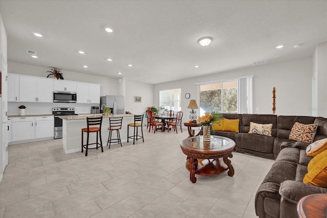 living room featuring a textured ceiling and light tile patterned floors