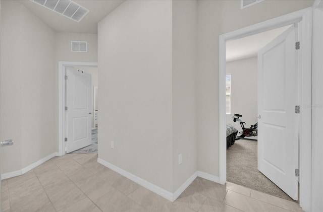 hallway featuring light colored carpet