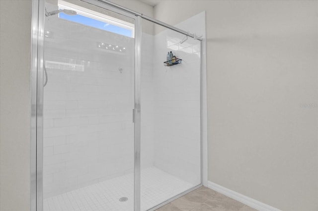 bathroom with a shower with door and tile patterned flooring