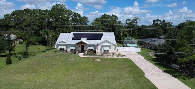 view of front facade with solar panels and a front yard