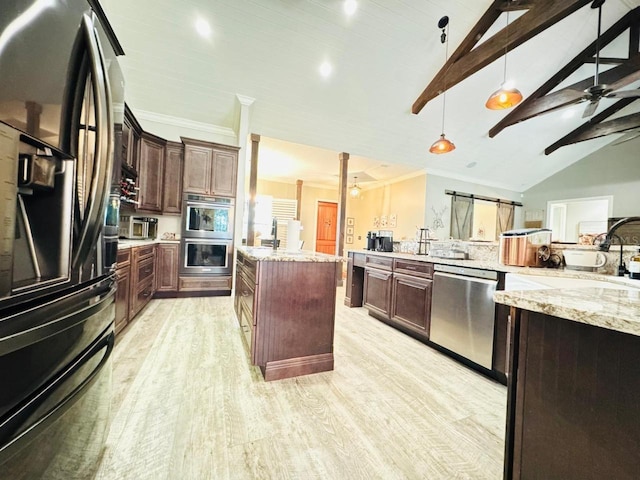 kitchen featuring light hardwood / wood-style flooring, stainless steel appliances, a barn door, lofted ceiling with beams, and pendant lighting