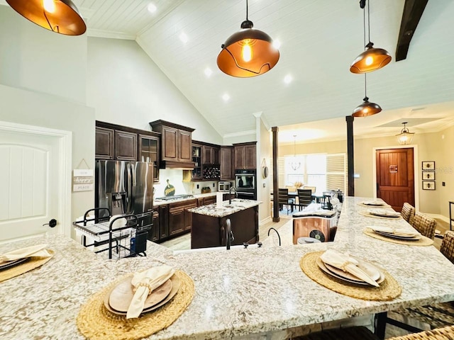 kitchen with a spacious island, stainless steel appliances, dark brown cabinetry, and decorative light fixtures