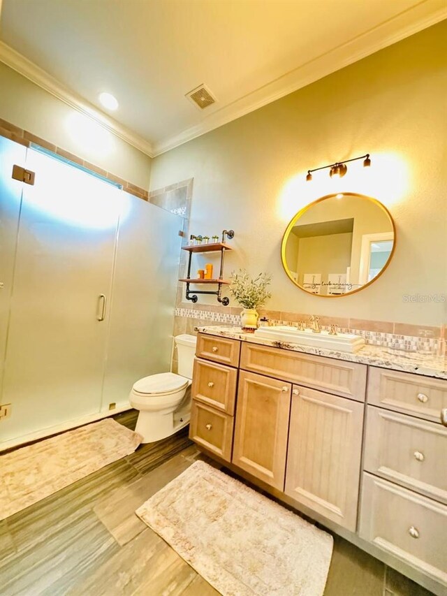 bathroom with vanity, an enclosed shower, toilet, and crown molding