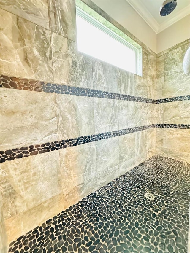 interior details with crown molding and tiled shower