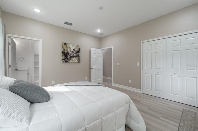 bedroom featuring a closet, a spacious closet, and light hardwood / wood-style flooring