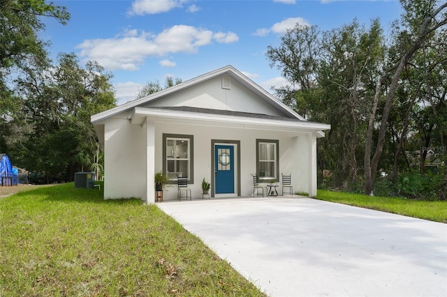 view of front facade featuring central air condition unit, covered porch, and a front lawn