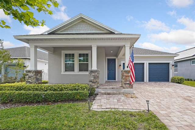 view of front of property featuring a front lawn, a garage, and covered porch