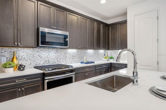 kitchen featuring backsplash, sink, dark brown cabinetry, and stainless steel appliances