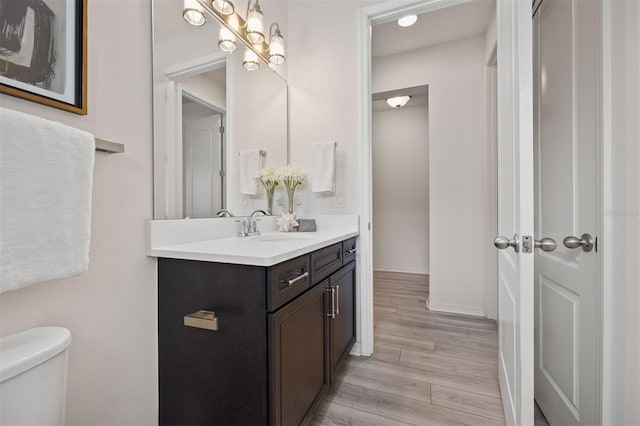 bathroom featuring vanity, hardwood / wood-style flooring, and toilet