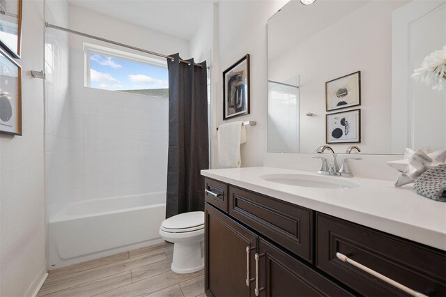 full bathroom with hardwood / wood-style floors, vanity, toilet, and shower / bathtub combination with curtain