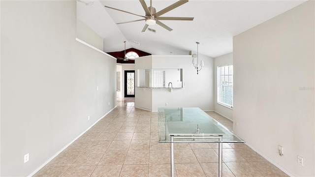 interior space featuring lofted ceiling, sink, light tile patterned flooring, and ceiling fan with notable chandelier