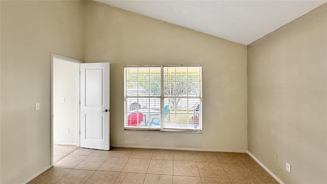 unfurnished room featuring high vaulted ceiling and light tile patterned floors