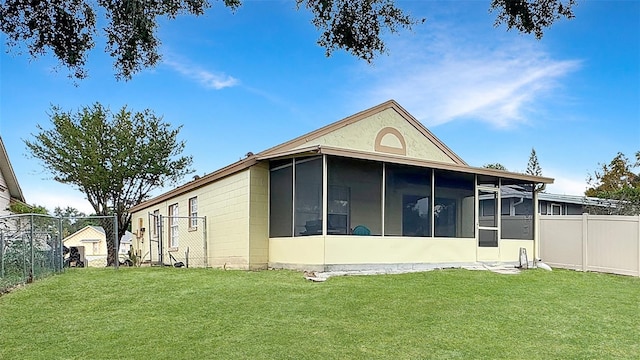 rear view of property with a sunroom and a yard