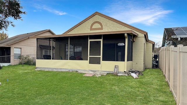 back of house featuring a sunroom and a yard