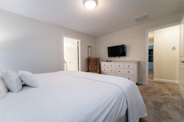 bedroom featuring a textured ceiling, carpet floors, and ensuite bath